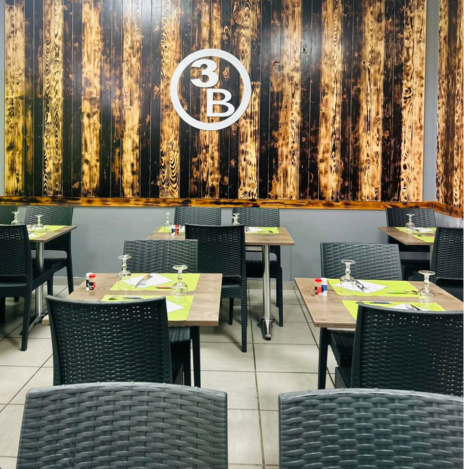 Salle du restaurant Les 3 B avec le mur en bois brûlé et le logo 3B